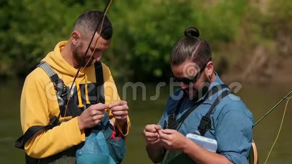 两个男人手里拿着钓竿头发浅黑的渔夫视频的预览图