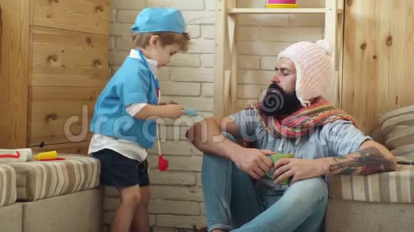 以医生的形式出现的男孩对一个留胡子的人很敏感这是非常重要的穿着医院礼服的可爱小男孩视频的预览图