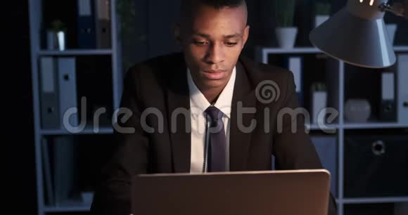 一个在办公室笔记本电脑上工作到深夜的糊涂商人视频的预览图