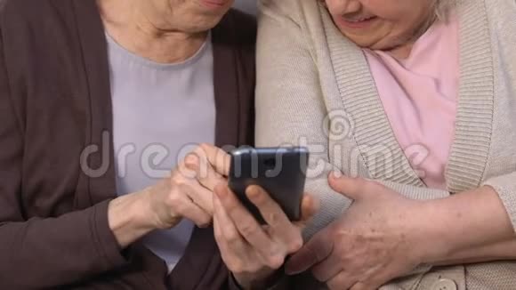快乐的女人在智能手机上看有趣的照片笑着回忆过去视频的预览图