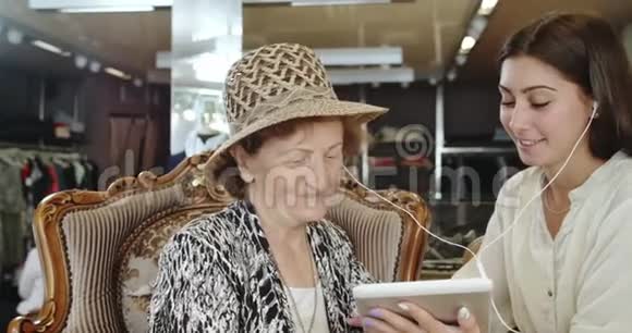 孙女教老太太如何在数码平板电脑上听音乐视频的预览图