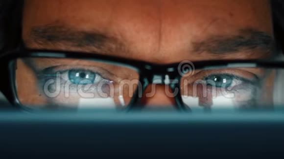 用蓝眼睛编程电脑和摘下眼镜来揉眼睛的男人视频的预览图
