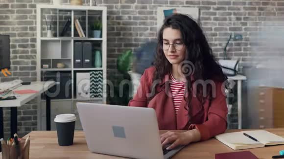 忙碌的年轻妇女在合用的办公室里用电脑打字视频的预览图