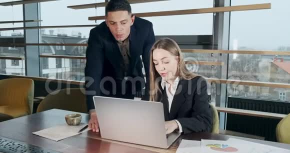 一个男人和一个女人在明亮的现代办公室里用笔记本讨论工作的肖像相关男性视频的预览图