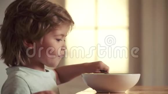 为孩子们提供食物和饮料童年可爱的小笑男娃娃的肖像金发从盘子里吃视频的预览图