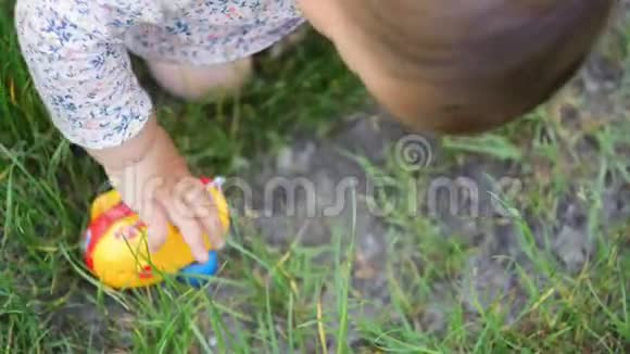一个小女孩蹒跚学步或穿着衣服在户外玩塑料汽车玩具童年活动视频的预览图