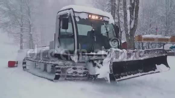 滑雪场娱乐活动滑雪场的雪修饰机雪洗衣机驱赶离开平坦的道路视频的预览图
