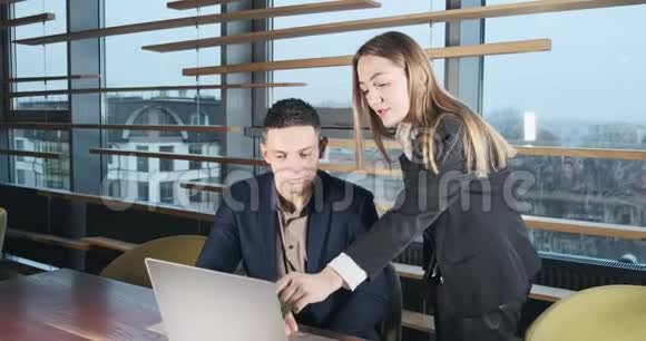 一个男人和一个女人在明亮的现代办公室里用笔记本讨论工作的肖像关心的女性视频的预览图
