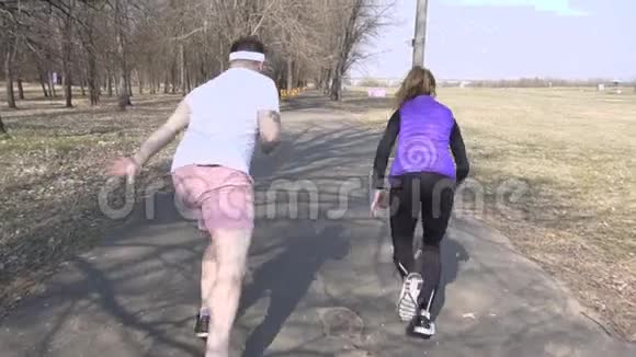 白种人男女朋友在春季公园训练运动和赛跑马拉松慢动作视频的预览图