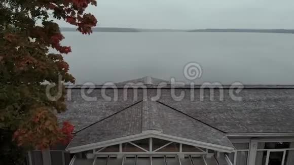 晚上照相机飞过一间私人住宅的屋顶朝湖飞去继续飞过水面视频的预览图