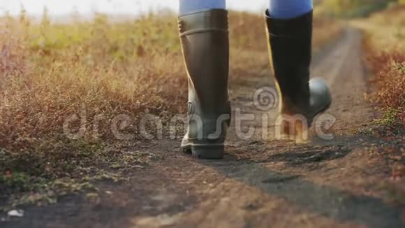 穿着橡胶靴的农夫在路上行走腿上有特写镜头视频的预览图