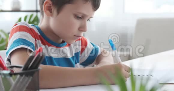 男孩拿着笔在书里写作视频的预览图
