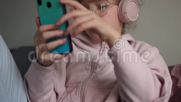 戴着电话眼镜的女学生通过无线耳机听音乐卷曲可爱少年的亲密画像视频的预览图