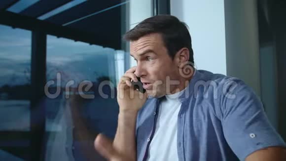 商人在窗户附近说话紧张的男人解释他的位置视频的预览图