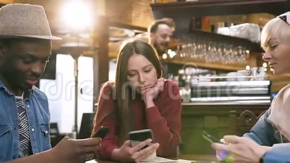 公司的多民族朋友用智能手机在酒吧酒吧当他们的男性朋友来的时候视频的预览图
