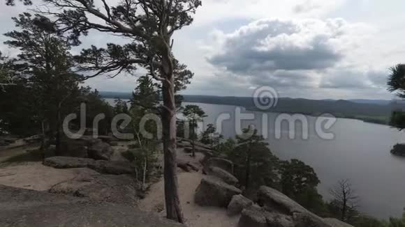 从山上看岩石和树木从多云到阳光明媚视频的预览图