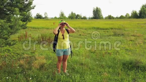 一位女游客走过一片森林透过望远镜看下一步该去哪里视频的预览图