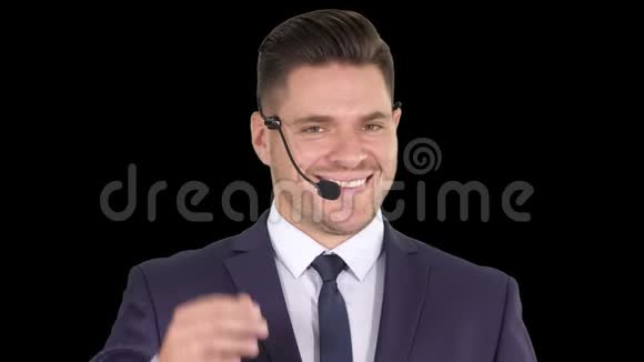 英俊的商人带着耳机看着镜头微笑着阿尔法频道视频的预览图