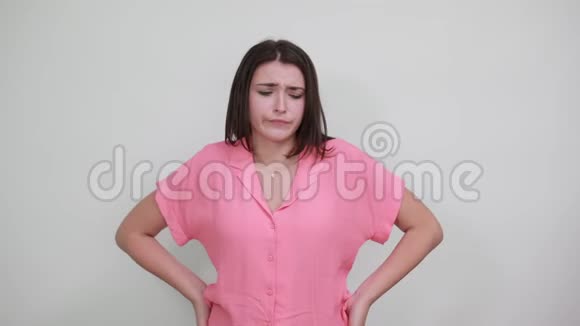 一位穿着粉红色衬衫的白种人年轻女士举着头看上去很困惑视频的预览图