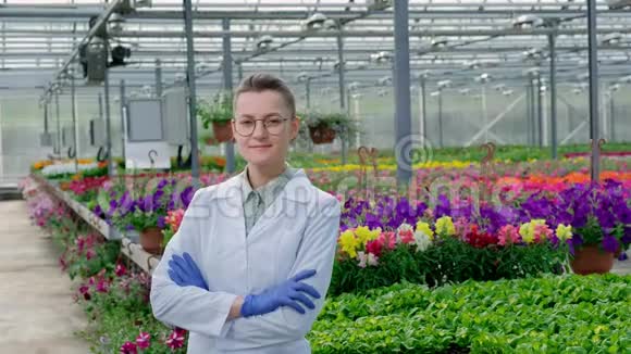 年轻漂亮的中年妇女戴着眼镜穿着白色外套戴着蓝色橡胶手套一位科学家农学家摆着姿势视频的预览图