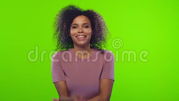 黑人妇女在镜头前露出洁白的牙齿同时在彩色钥匙上感到快乐视频的预览图