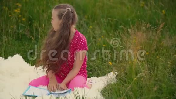 女孩坐在草坪上看书视频的预览图