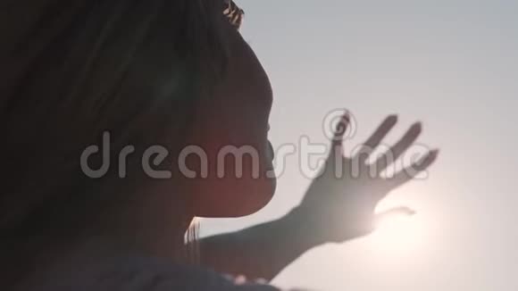 女孩用手看太阳一位年轻女子在阳光下的肖像视频的预览图
