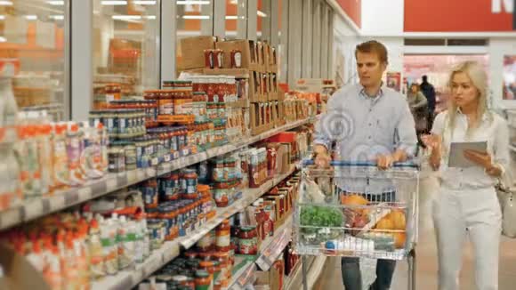 顾客在超市购物及在平板电脑上查询产品清单视频的预览图