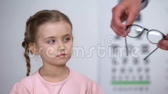 不舒服的小女孩拒绝眼镜孩子感到不安全的眼镜不舒服视频的预览图