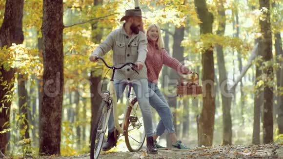 欢快的年轻女子和留着秋叶胡子的男人的肖像浪漫的秋天情侣相爱修理和修理视频的预览图