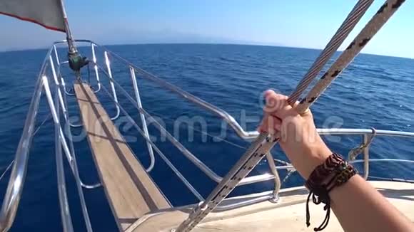 在晴朗的晴天游艇迅速驶过蔚蓝的大海驶向小岛游艇的船头特写视频的预览图