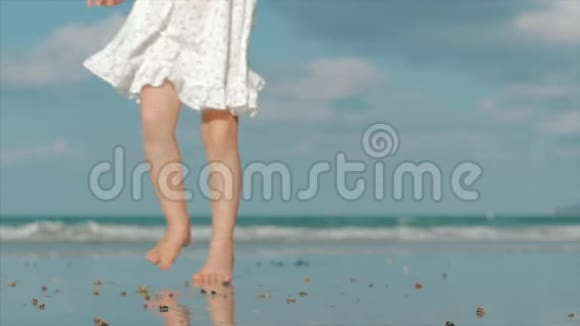 孩子们的剪影在热带海洋背景下沿着热带海滩的湿沙上行走的脚概念视频的预览图