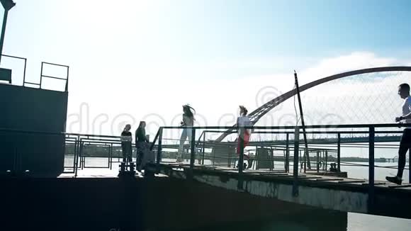 一群人跑到桥上在海边的青春朋友们玩得开心快乐放松玩得开心海边视频的预览图