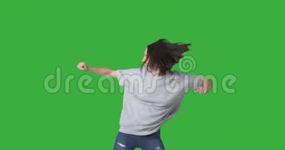 快乐的女人享受绿色背景下的舞蹈视频的预览图