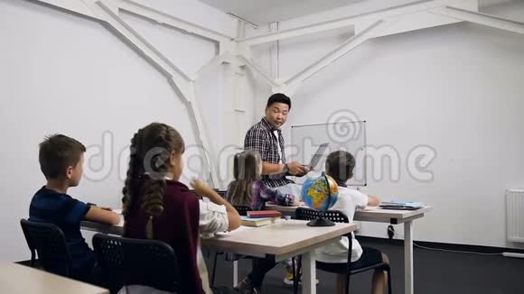 一个白人女学生坐在学校后面举手回答韩国老师的问题视频的预览图
