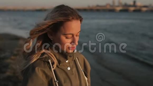 站在河边用耳机听音乐的女人视频的预览图