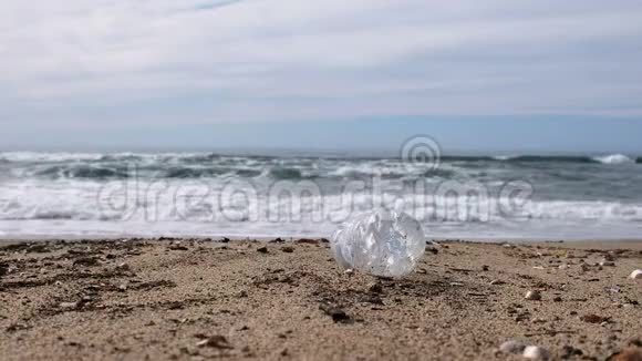 海滩上的塑料瓶垃圾在模糊的波浪运动背景下行星4k视频的预览图