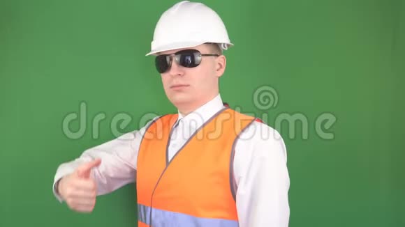 男老板戴着黑色眼镜在一个建筑物体上展示的手势都很好竖起大拇指绿色背景hromakey视频的预览图