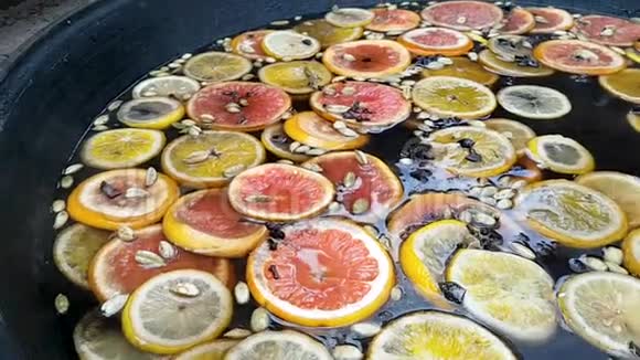 做一杯覆盖的葡萄酒饮料橙子柠檬葡萄柚和豆蔻的特写镜头这些东西在热水表面而且是沸腾的视频的预览图