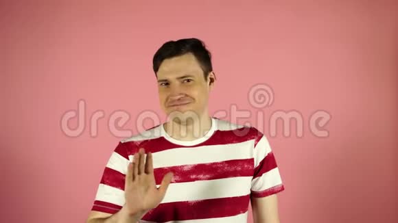 一个穿着粉红色背景条纹t恤的男人看着摄像机说不视频的预览图