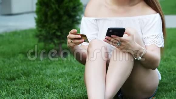 一位年轻女性通过手机进行网上购物然后输入一个信用卡号码视频的预览图