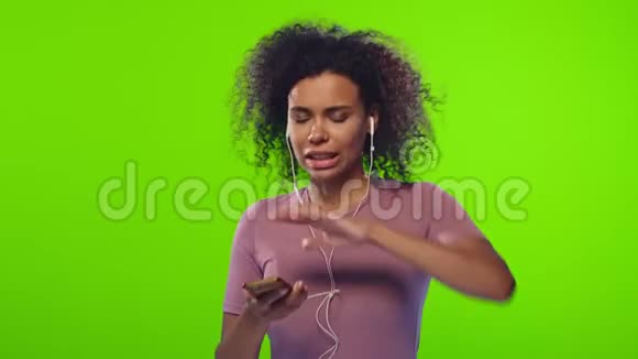 女性用耳机跳舞听歌用智能手机控制色度键视频的预览图