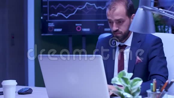 精疲力竭的穿着正装的人在笔记本电脑上工作视频的预览图