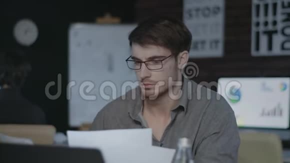 集中业务分析师在黑暗的办公室里看文档和笔记本电脑屏幕视频的预览图