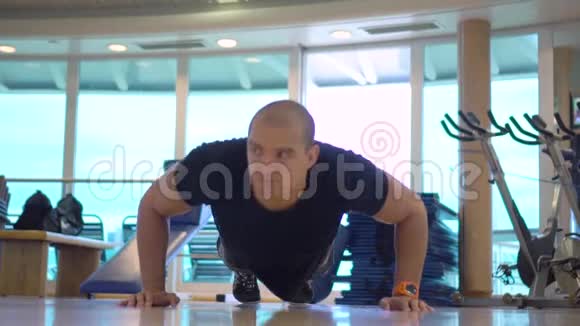 年轻运动员在健身房做俯卧撑锻炼视频的预览图
