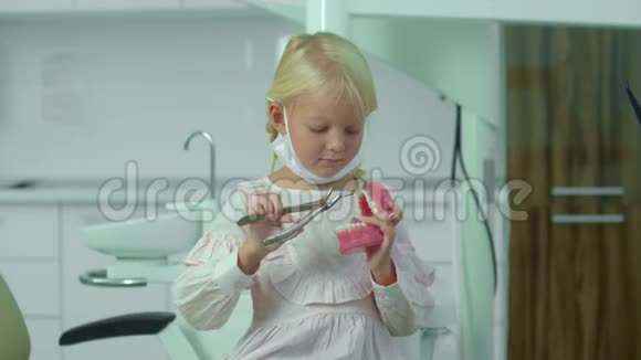 戴面具的女孩手里拿着钳子和医用颚骨视频的预览图