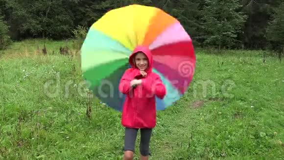 雨中的孩子下雨天在公园里玩户外女孩旋转伞视频的预览图