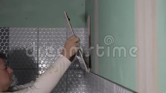 陶工把瓷砖放在墙上专业瓷砖铺设浴室墙面瓷砖视频的预览图