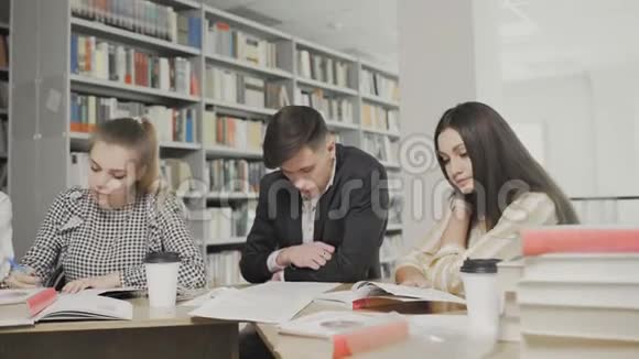 在大学图书馆坐在桌旁准备考试的学生视频的预览图