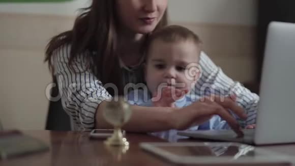 忙碌的年轻母亲在家工作孩子在她的大腿上孩子很淘气他不想平静孩子视频的预览图